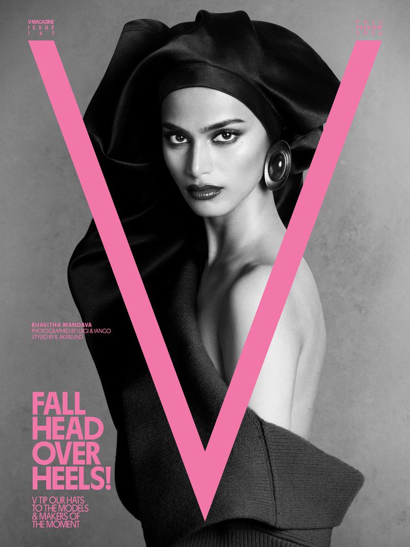 Model Bhavitha Mandava posing in a black sculptural headwrap behind a large pink letter V on the cover of V Magazine
