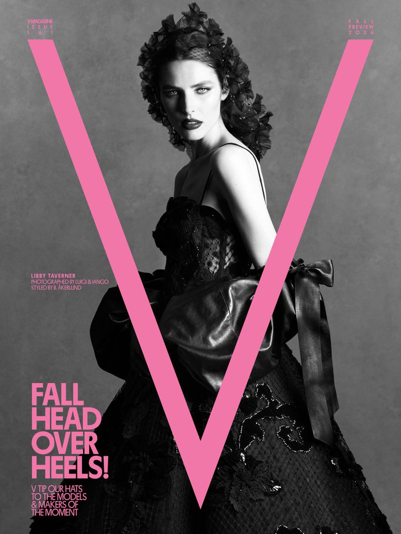 Model in black evening gown with floral headpiece posing behind a large pink V letter for V Magazine issue 161 cover