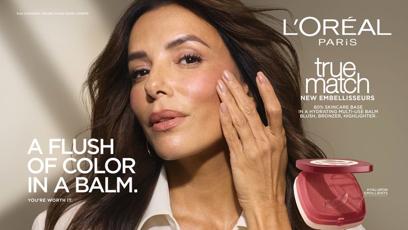 Eva Longoria touching her cheek highlighting blush makeup next to an open compact of L'Oreal True Match balm.