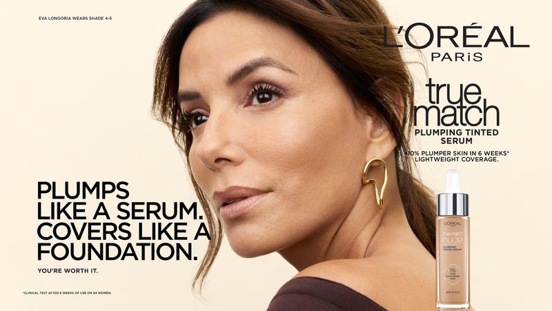 Eva Longoria in a close-up beauty portrait wearing a gold earring next to a bottle of L'Oréal Paris True Match tinted serum.