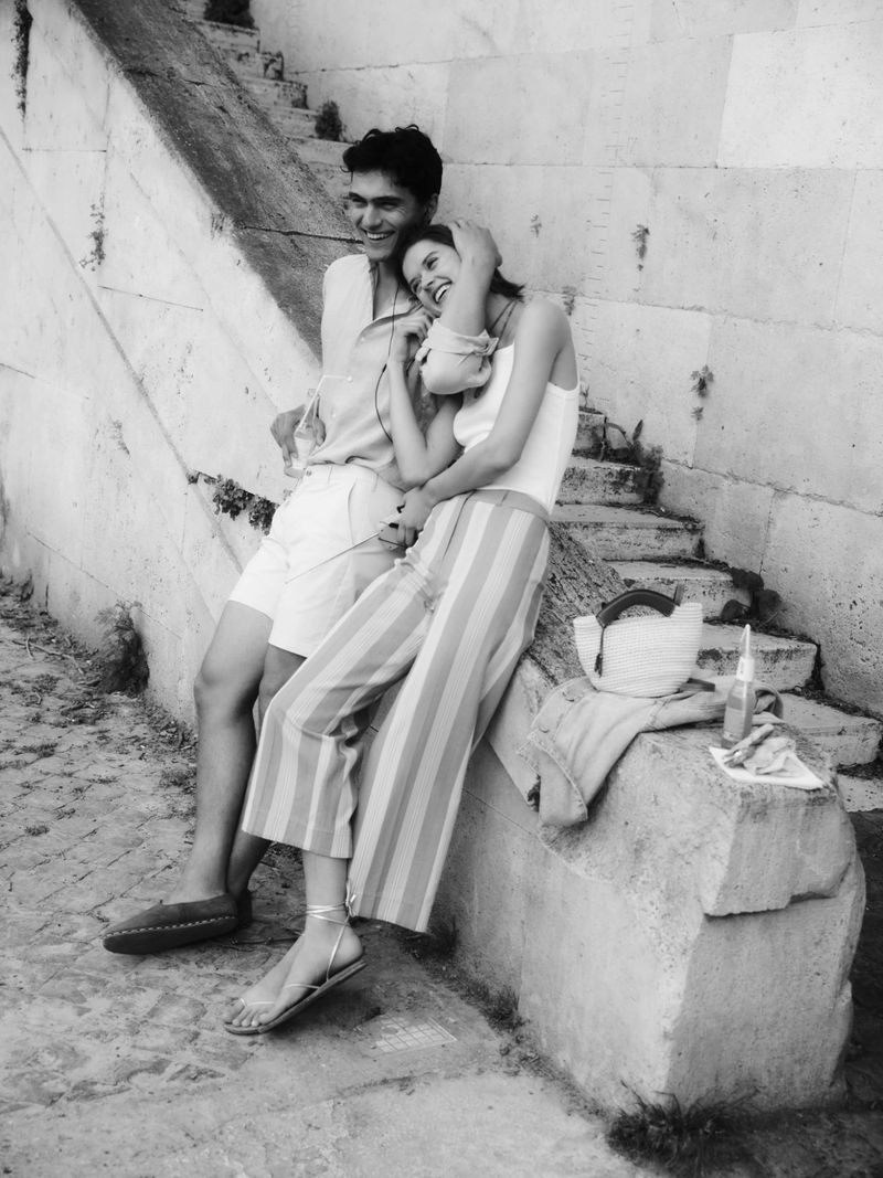 Man and woman smiling while leaning against stone stairs for Tuckernuck campaign