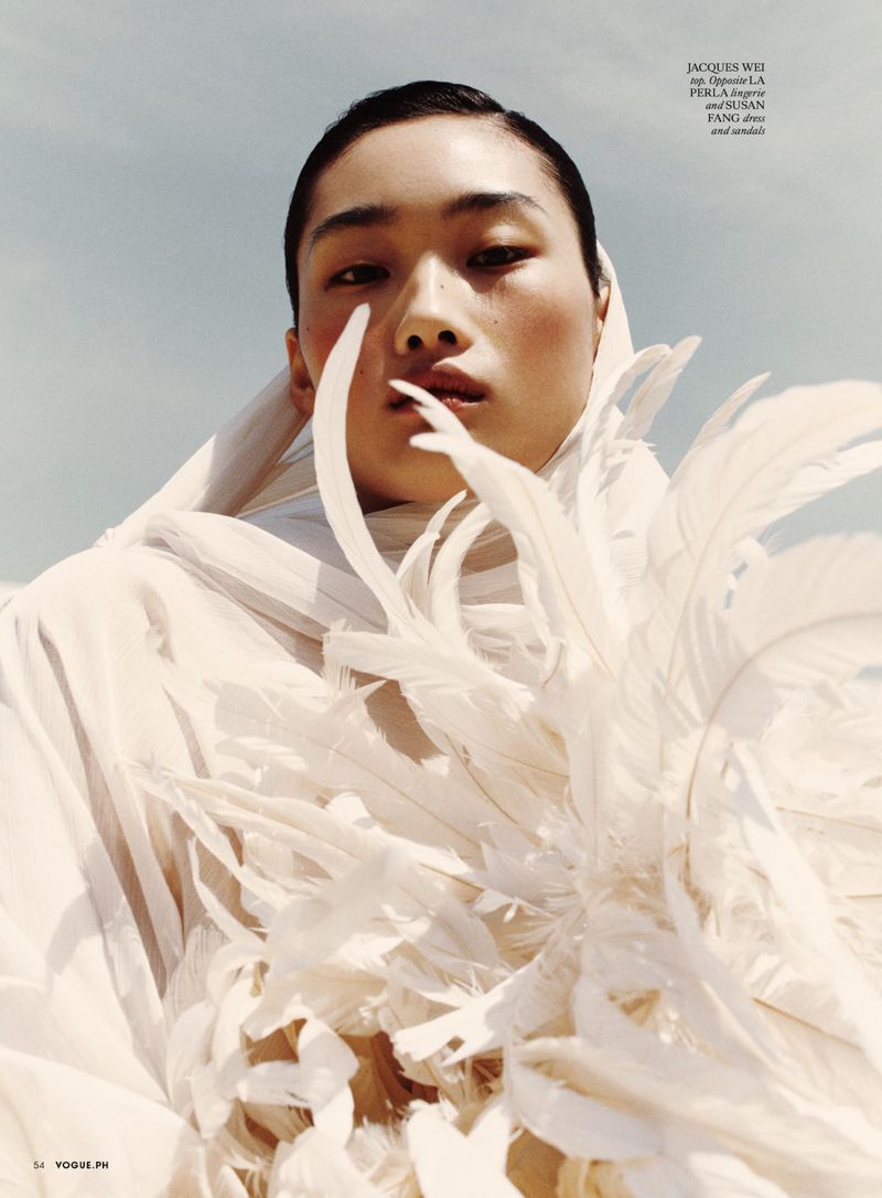 Fashion editorial shot of an Asian woman wearing a white feathered garment against a clear sky, with Jacques Wei text visible.