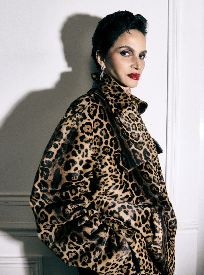 Farida Khelfa wearing a leopard print jacket against a plain wall for Vanity Fair Espana
