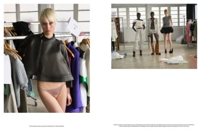 Model with blonde hair in a black cropped leather jacket stands in a backstage fitting room environment.