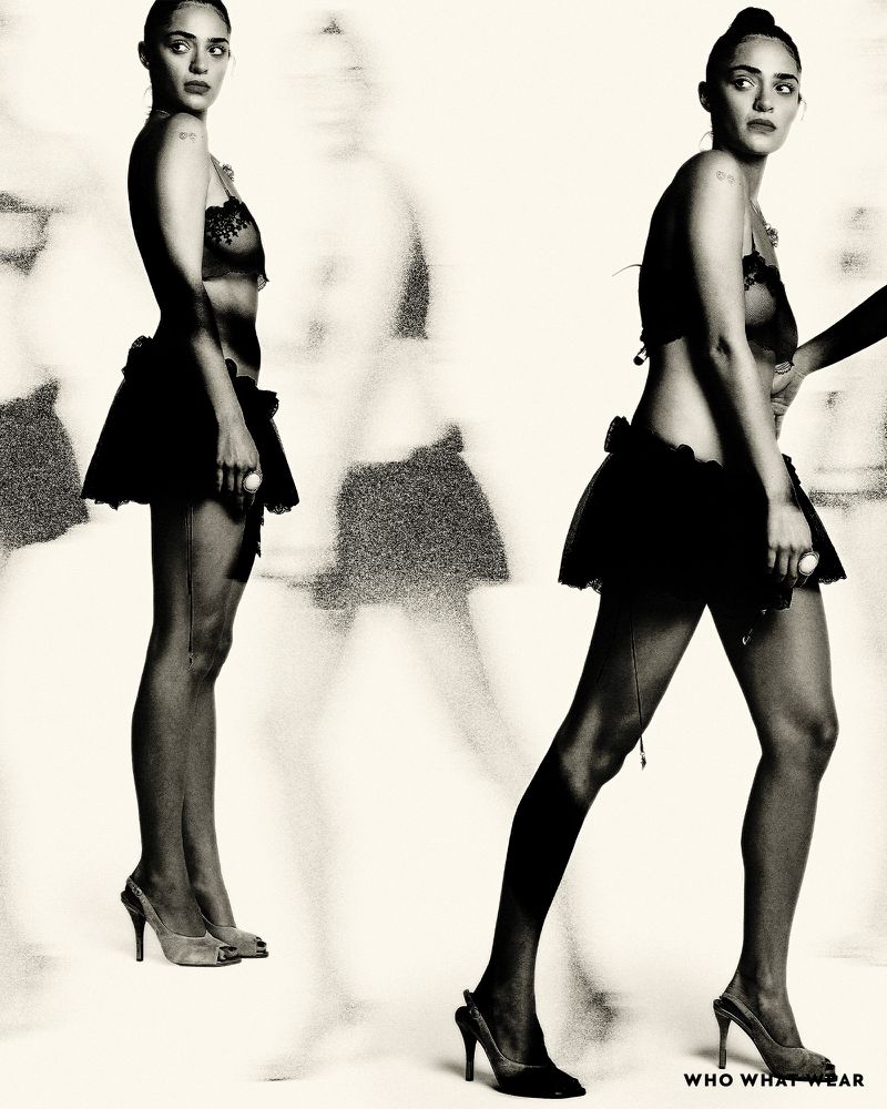Artistic black-and-white studio portrait of an adult female model in lingerie and heels, featuring a ghosted background figure.