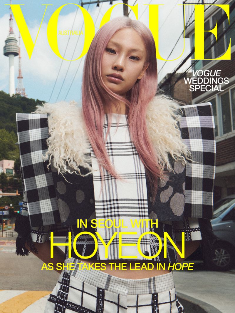 Hoyeon Jung with pink hair posing in a black and white plaid top on the Vogue Australia cover in Seoul.