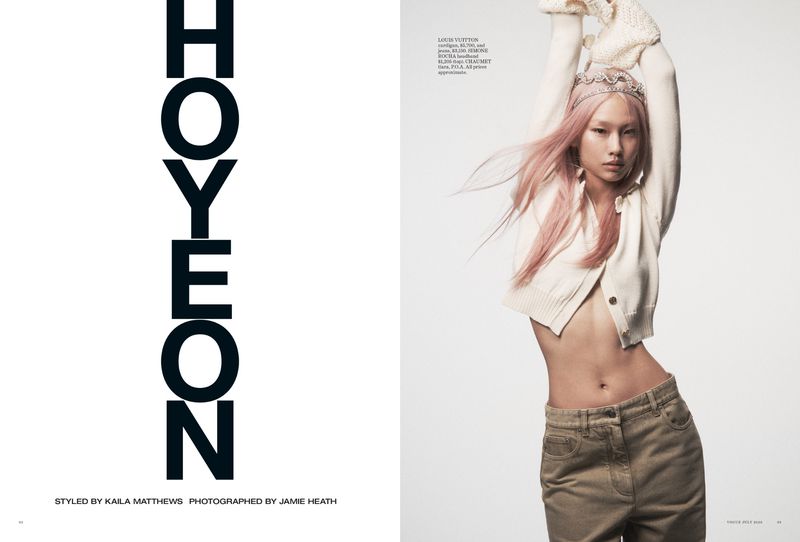 Model Hoyeon posing with pink hair in a cropped cream cardigan and khaki trousers for a Vogue Australia editorial spread.
