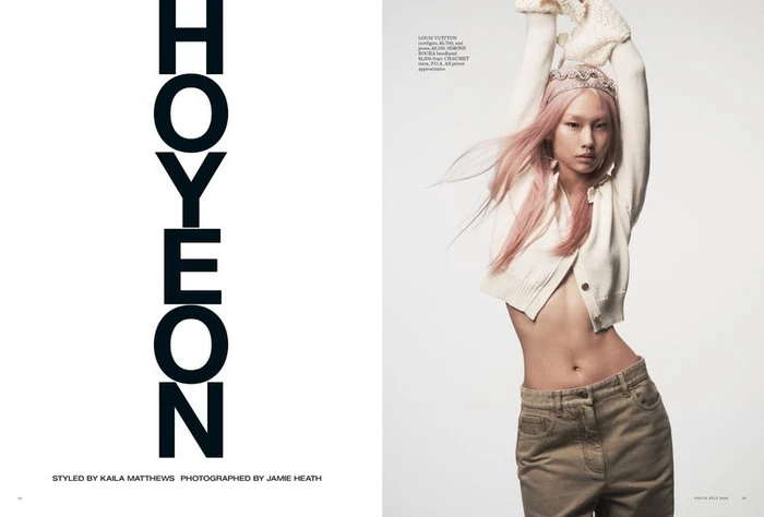 Model Hoyeon posing with pink hair in a cropped cream cardigan and khaki trousers for a Vogue Australia editorial spread.