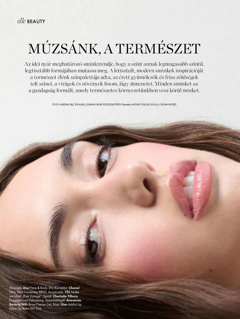 Close-up beauty portrait of a woman lying down with soft pink blush and natural lips for an Elle magazine editorial.