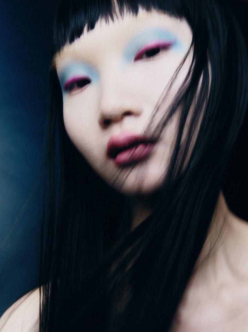 Close-up portrait of a model with dark hair and colorful eye makeup for Narcisse Magazine