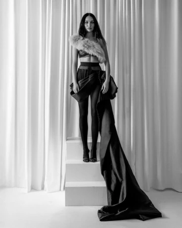 Full-length black and white portrait of Maddie Ziegler posing on white steps against draped curtains for DSECTION Magazine.