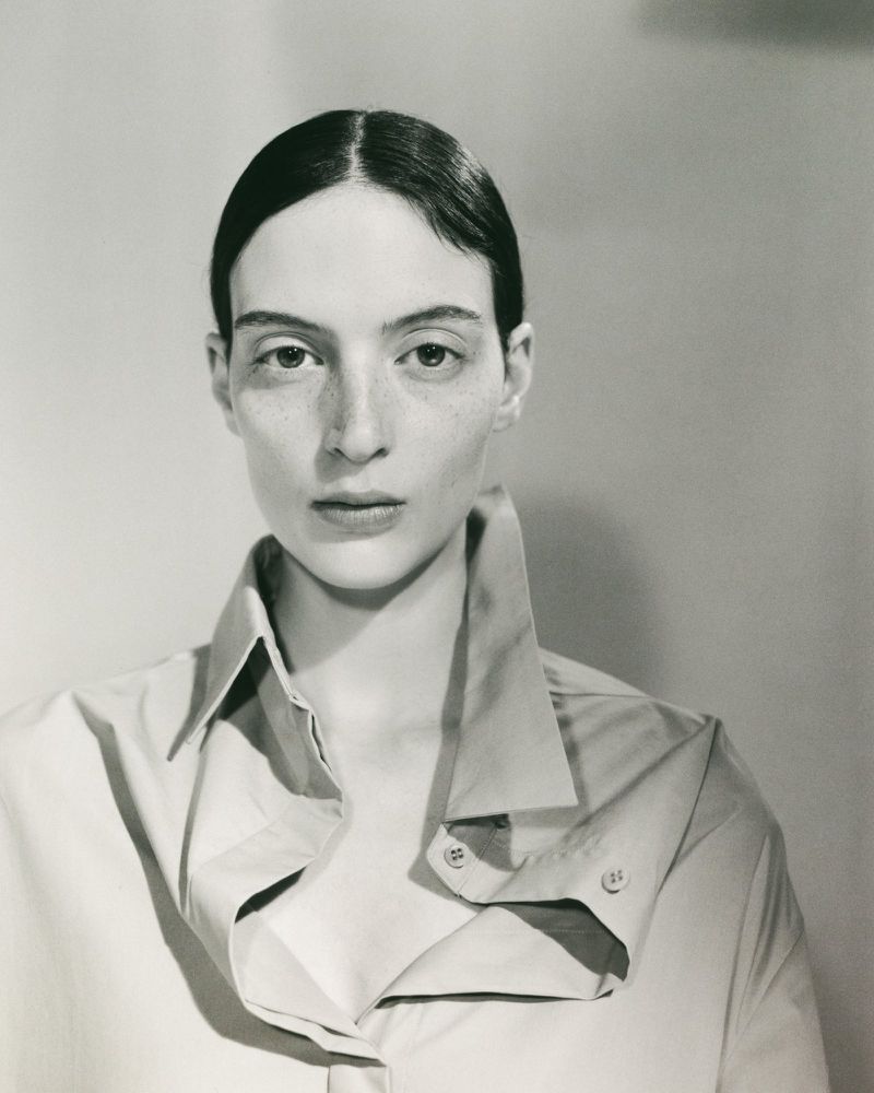 Model Lila Braghero wearing an oversized collared shirt with popped lapels against a neutral studio backdrop.