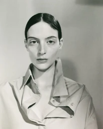Model Lila Braghero wearing an oversized collared shirt with popped lapels against a neutral studio backdrop.