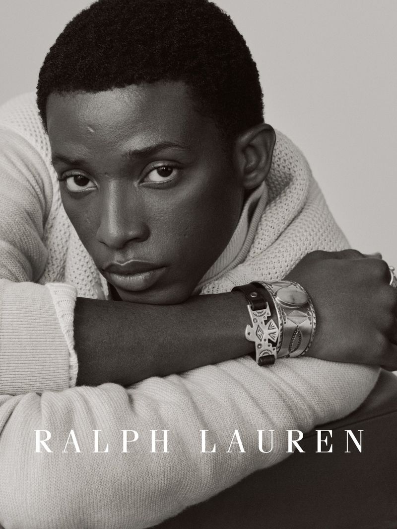 Monochrome portrait of model Gideon Adeniyi wearing a textured knit sweater and silver bracelets for Ralph Lauren.
