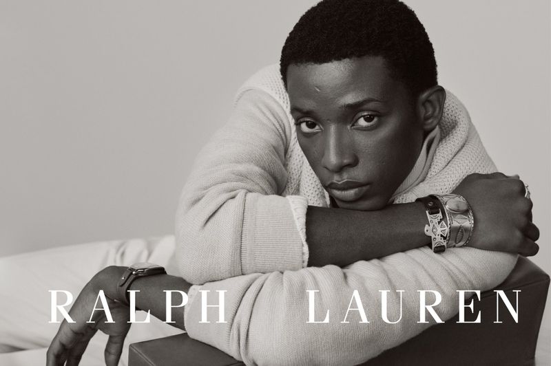Model Gideon Adeniyi posing in a textured knit sweater with watch and cuff bracelet in a black and white Ralph Lauren campaign.