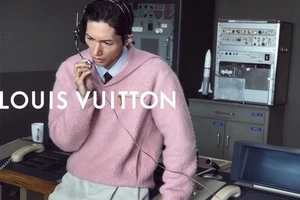 Model Takahiro Oda wearing a pink knit sweater and vintage communications headset at a control desk in a Louis Vuitton campaign.