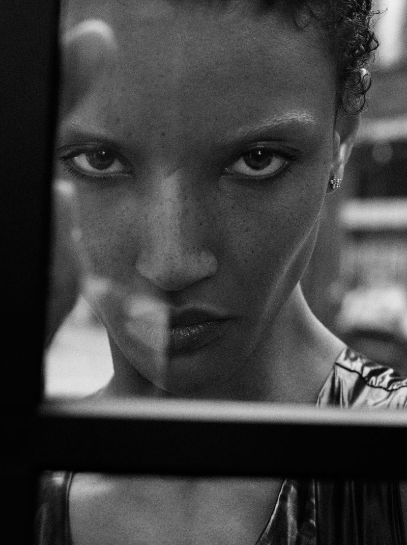 Black and white close-up portrait of model Georgia Palmer looking through a dark frame for Harper's Bazaar Turkey.