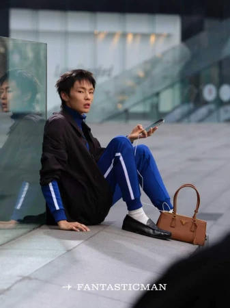 Carrying his girlfriend's bag-or is ...
