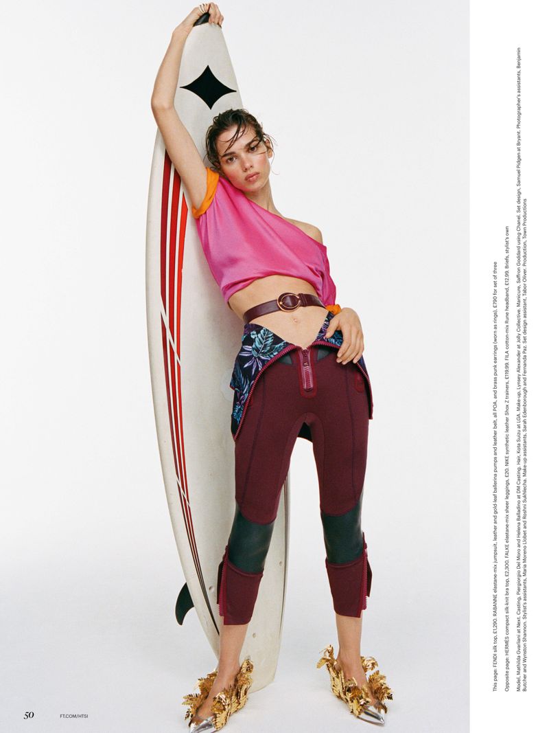 Model Mathilda Gvarliani holding a surfboard against a white background for Financial Times HTSI Magazine