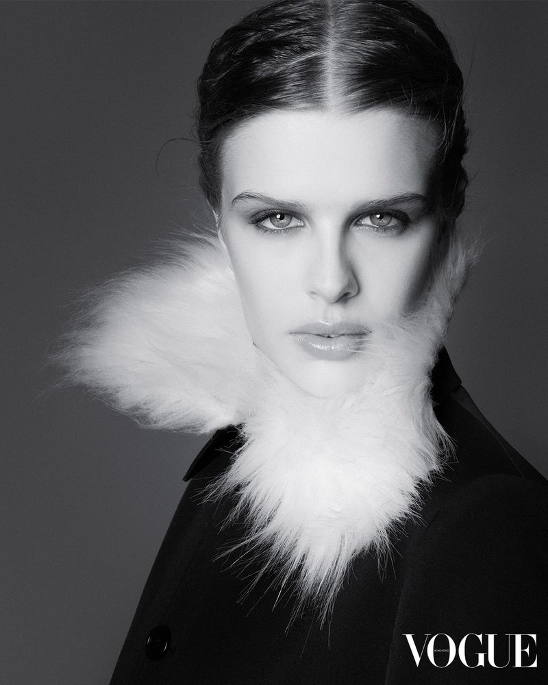Black and white portrait of model Kenna Musel wearing a black coat and a textured white fur collar for Vogue Hong Kong.