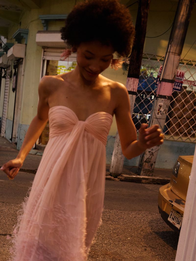 Lineisy Montero moving outdoors wearing a strapless blush pink feathered dress from Oscar de la Renta Pre-Fall 2026.