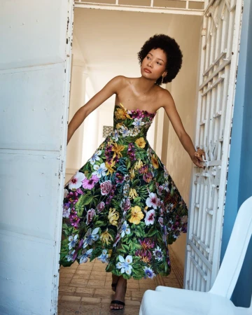 Model Lineisy Montero in a strapless floral print gown posing in an open doorway for Oscar de la Renta.