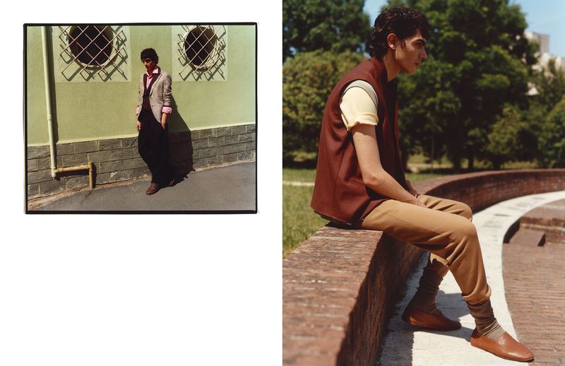 Fashion editorial spread featuring a man seated on a brick ledge in a brown vest alongside a framed portrait by a building wall.
