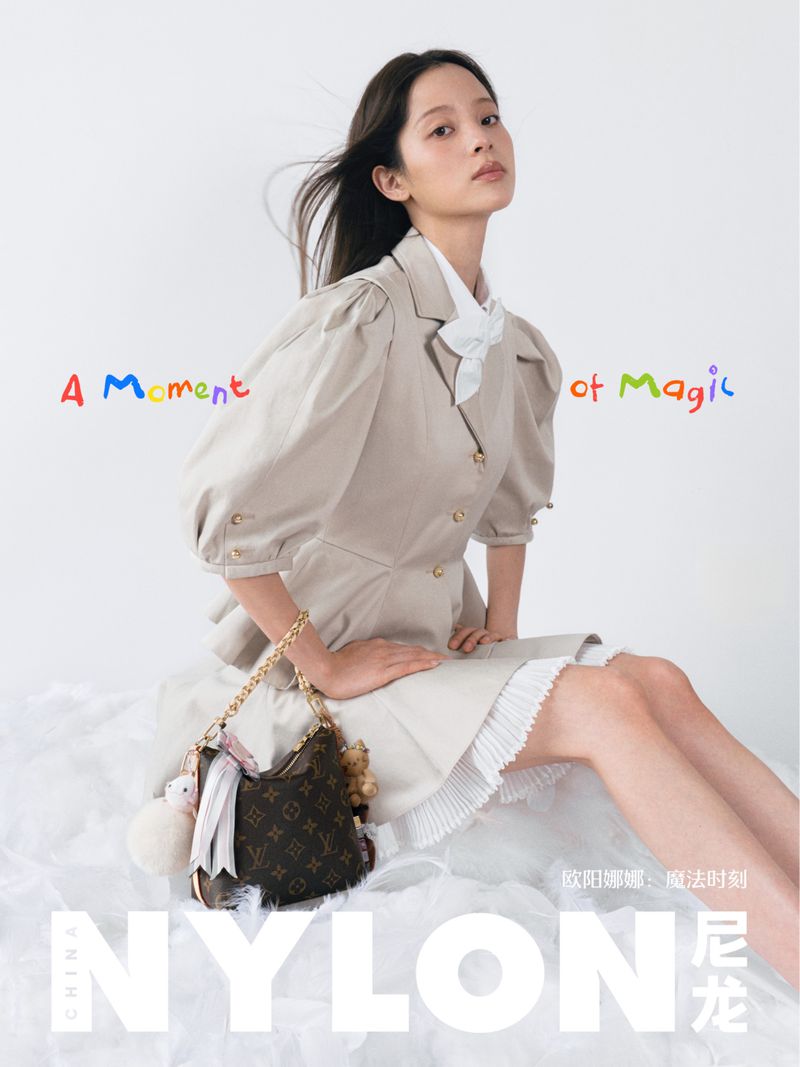 Entertainer Nana Ou-Yang poses in a beige puff-sleeve coat dress holding a monogram purse for a magazine cover.