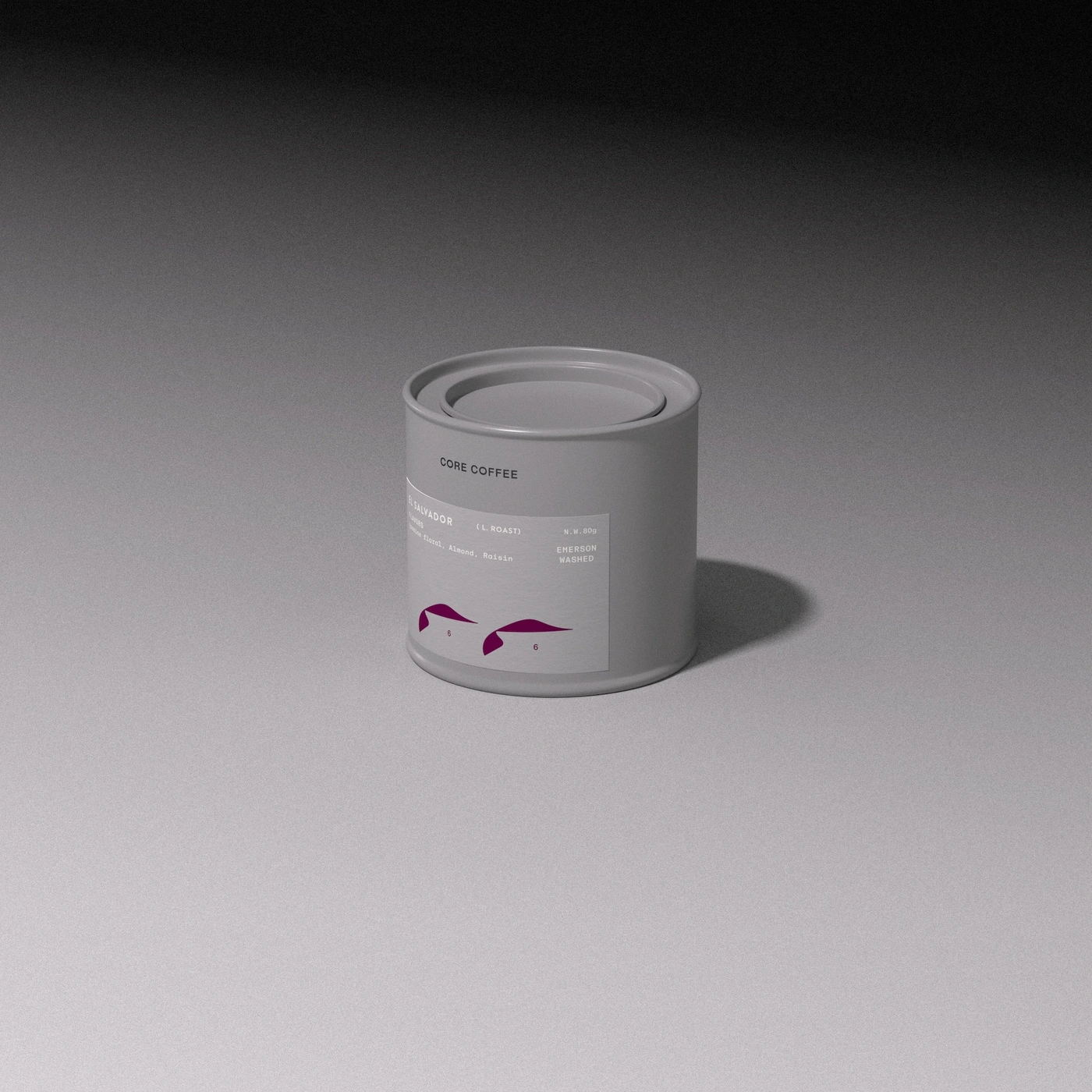 A light grey CORE COFFEE cylindrical canister with a minimalist label standing centered on a seamless grey studio surface.