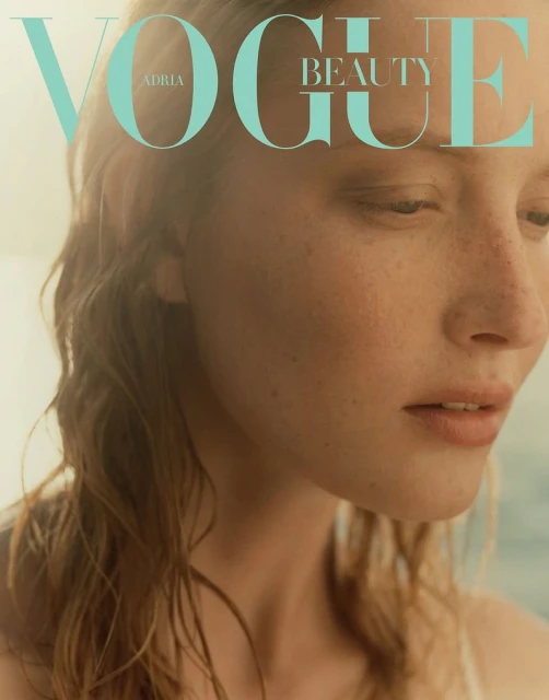 Vogue Beauty magazine cover featuring a close-up shot of a young fair-skinned woman with freckles, light hair, and a serene expression.
