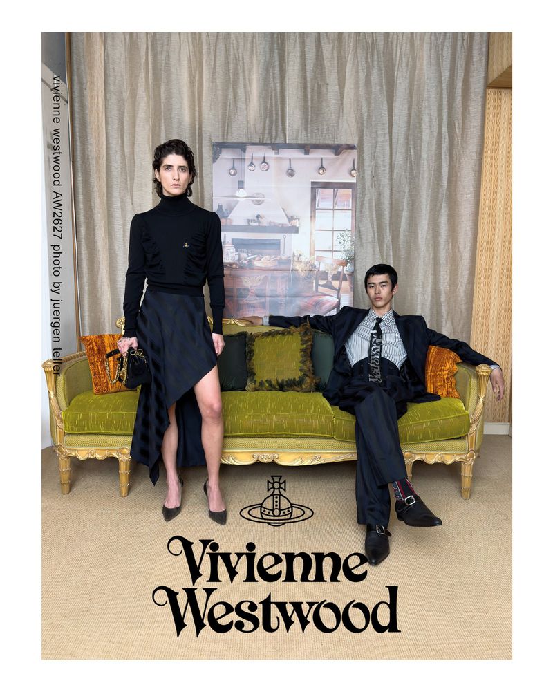 A standing model in a black turtleneck and skirt next to a seated man on a green sofa, photographed by Juergen Teller.