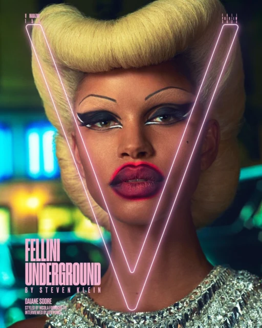 Close-up portrait of a woman with dramatic makeup, platinum blonde hair, and a neon V-shaped outline against a blurry city backdrop.