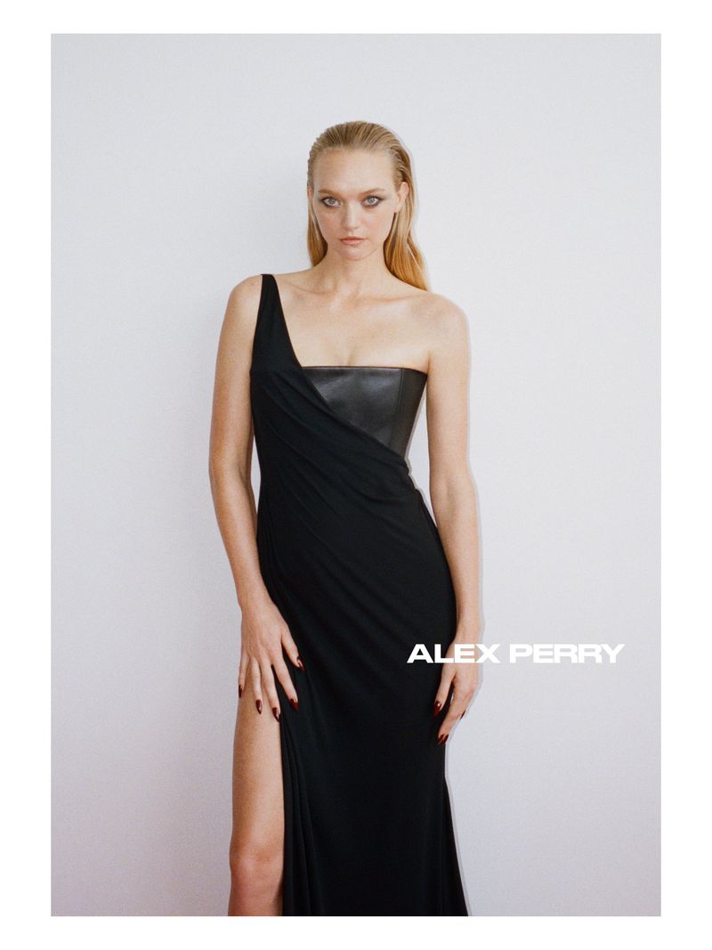 Model Gemma Ward in a black one-shoulder Alex Perry evening gown with a high slit against a white seamless background.