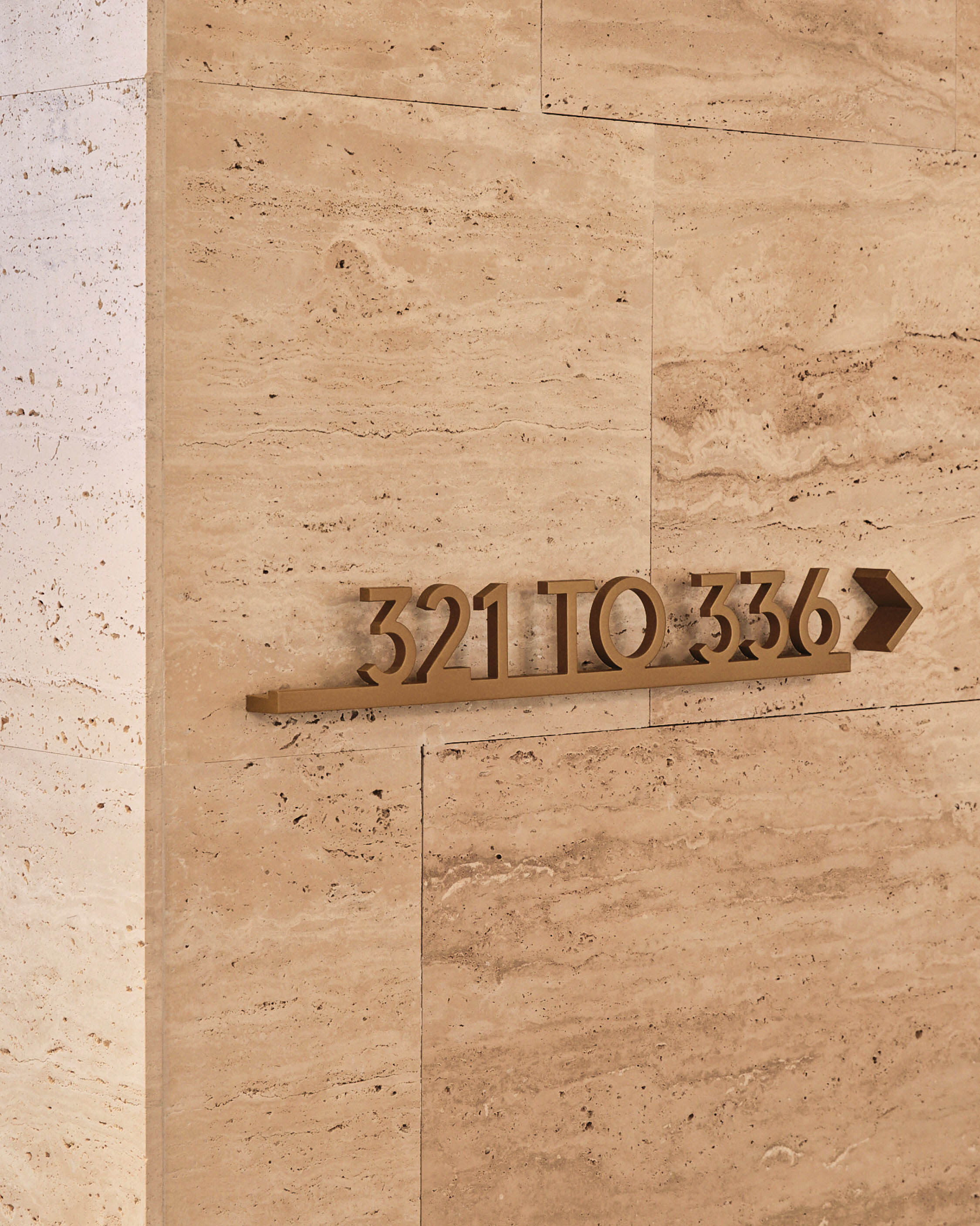 Bronze metal directional wayfinding signage reading 321 TO 336 mounted on a beige travertine stone wall.