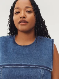 Model Imani Randolph wears a blue denim top with a wide square sailor collar against a light studio backdrop.