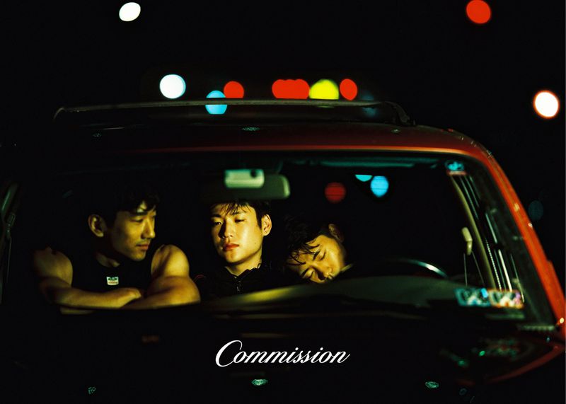Three people seated inside a dark car at night with bokeh lights glowing in the background, captured by Bella Newman for Commission SS26.