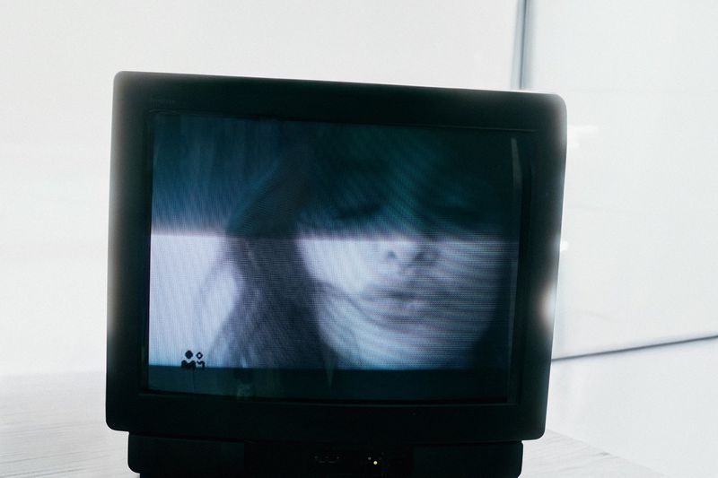 Vintage CRT television monitor displaying a distorted video screen capture of Penélope Cruz against a pale background.