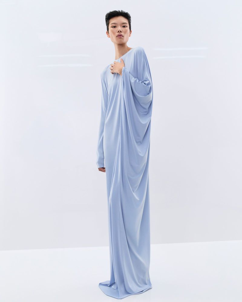 Model Kayako Higuchi wearing a floor-length draped powder blue gown against a bright white background for Tom Ford.