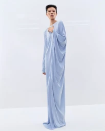 Model Kayako Higuchi wearing a floor-length draped powder blue gown against a bright white background for Tom Ford.