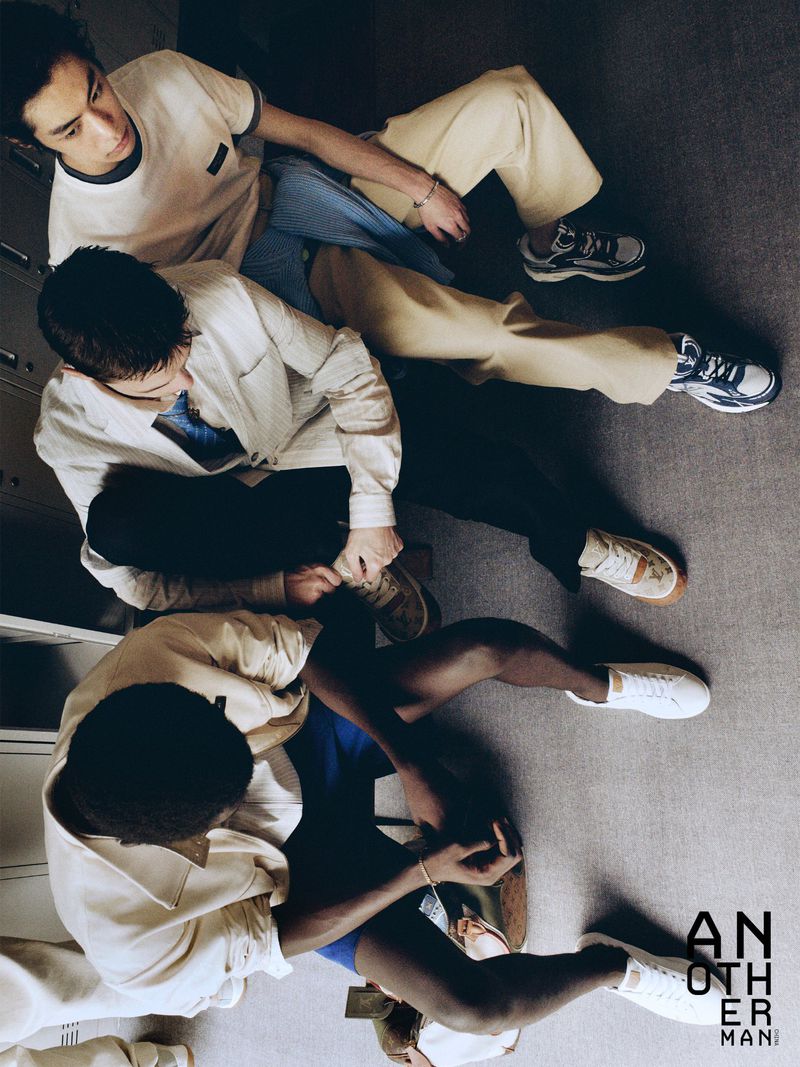 High-angle view of three male models seated on the floor in casual menswear for AnOther Man China.