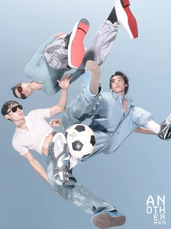Three male models floating dynamically in mid-air around a classic soccer ball against a pale blue studio background.