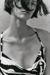Black and white close-up of model Valerie Scherzinger wearing a black and white patterned slip top with hair over her face.