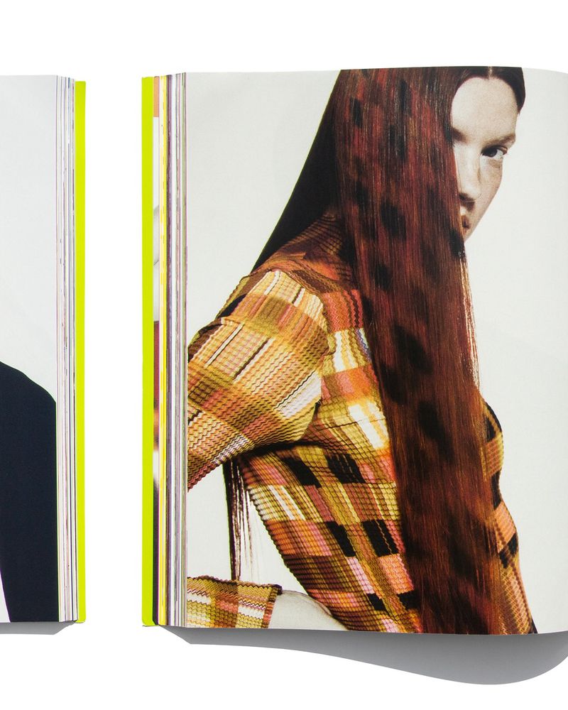 Model with dyed leopard-patterned red hair wearing a checkered plaid long-sleeve top in an open magazine layout.