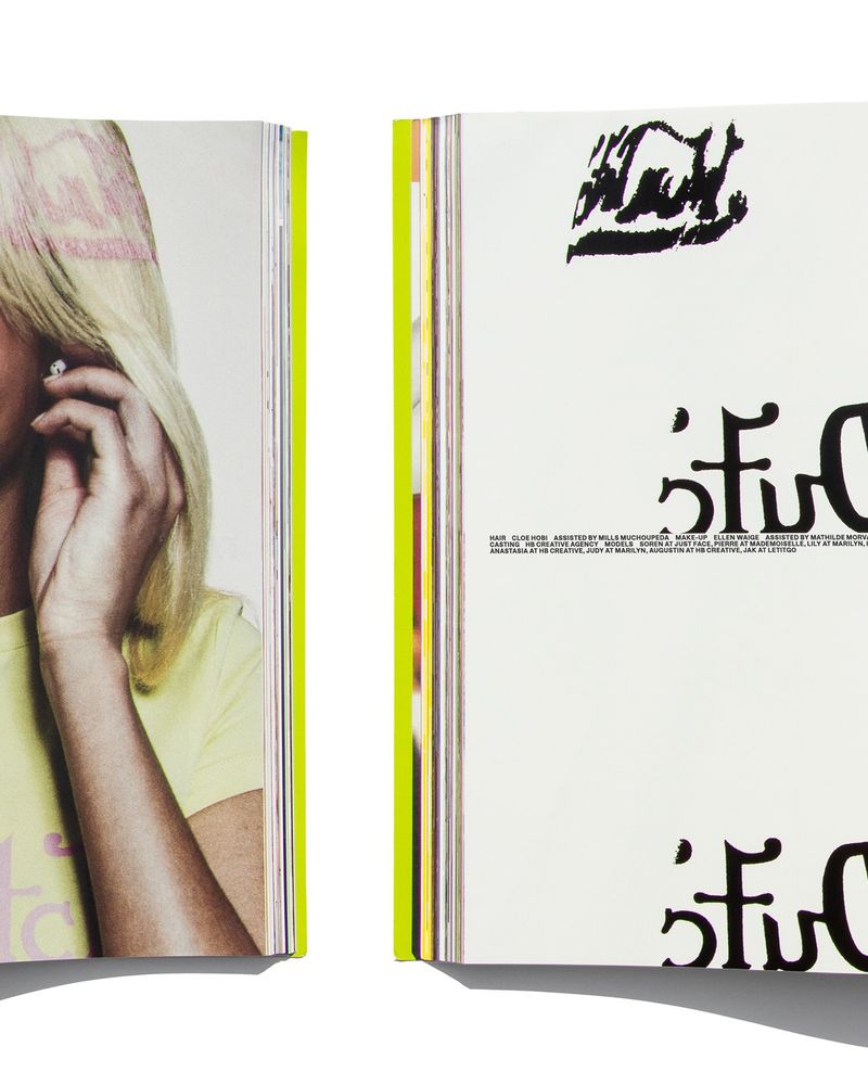 Cropped editorial magazine spread featuring a blonde model in a pale yellow t-shirt beside a page with bold black typography.