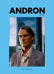 Magazine cover of Andron Journal featuring a middle-aged man in a light grey blazer and open-collar shirt against a blue border.