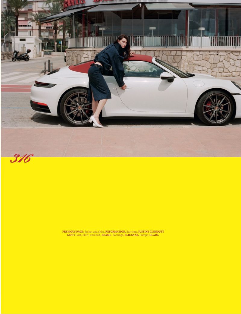 Model leaning against a white sports car on a sunny street for Heatline Magazine editorial shoot