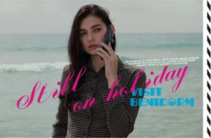 Model talking on a flip phone on a beach in a checked collared shirt with graphic magazine typography overlays.