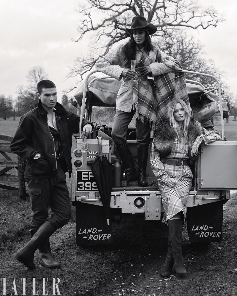 Three models posing by a vintage Land Rover in a rural landscape for Tatler U.K.