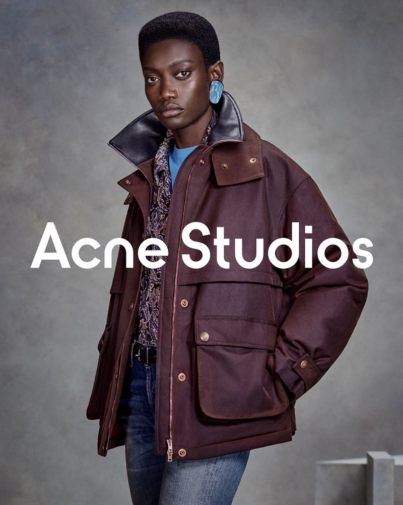 Fatou Kebbeh models an oversized burgundy utility jacket with an upturned leather collar in the Acne Studios FW26 campaign.
