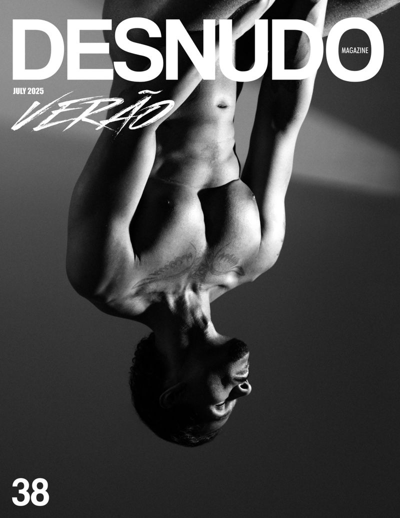 Black and white magazine cover featuring a muscular man in an upside-down pose, emphasizing his physique against a gray background.